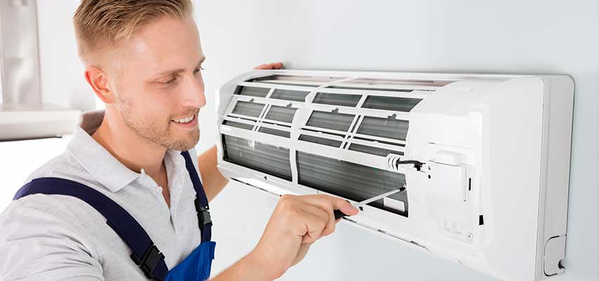 Technician working on an open AC unit