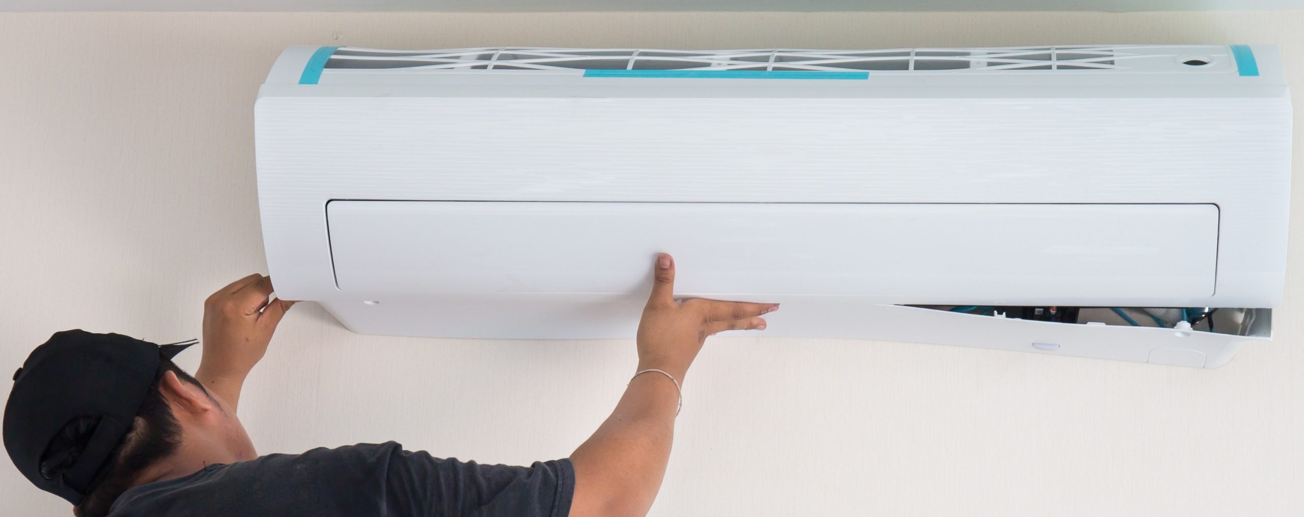 Person installing a wall-mounted air conditioner