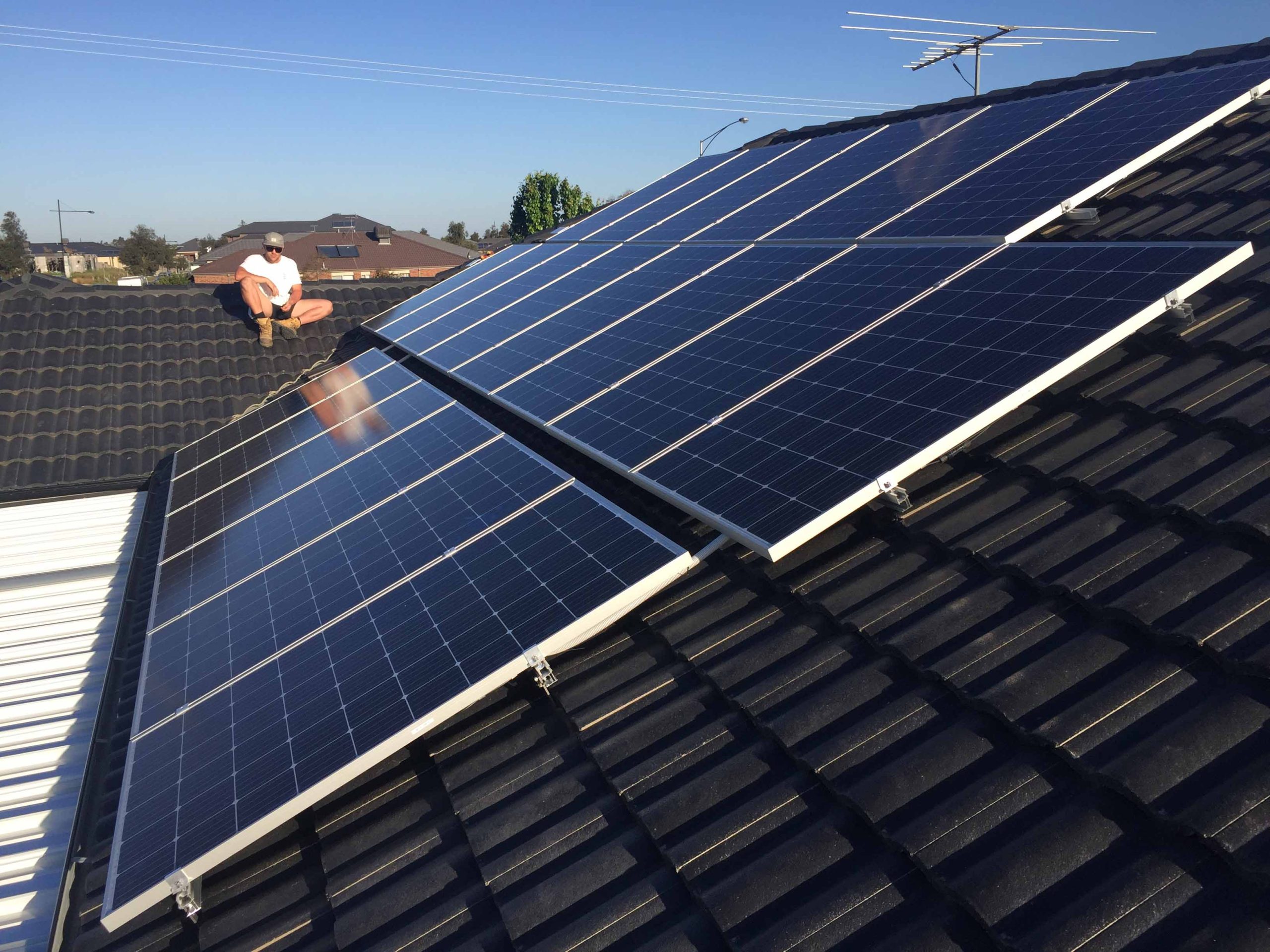 Roof with solar panels and person inspecting them